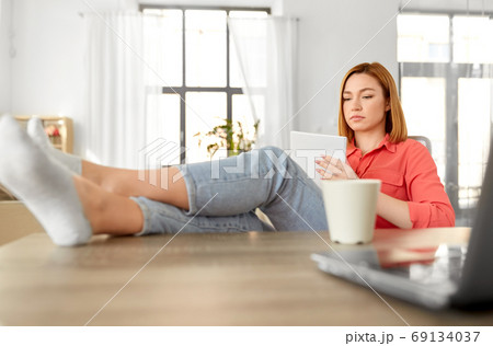 woman with notebook and laptop at home office 69134037