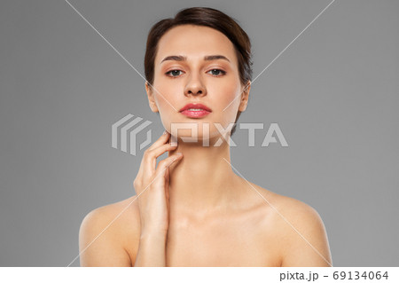 beautiful young woman touching her neck 69134064