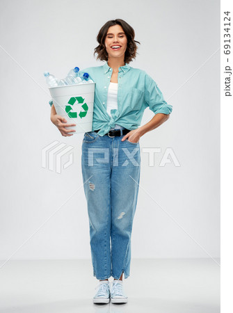 smiling young woman sorting plastic waste 69134124