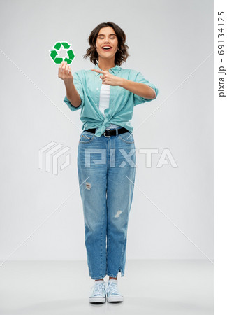 smiling young woman holding green recycling sign smiling young woman holding green recycling sign 69134125