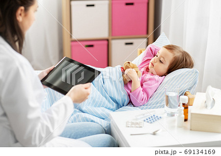doctor with tablet computer and sick girl in bed doctor with tablet computer and sick girl in bed 69134169