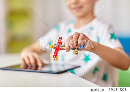happy little boy playing with airplane toy at home 69134303