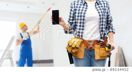 woman or builder with phone and working tools woman or builder with phone and working tools 69134452