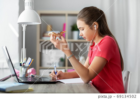student girl in earphones with pizza at home student girl in earphones with pizza at home 69134502