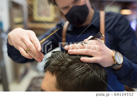 male hairdresser cutting hair at barbershop male hairdresser cutting hair at barbershop 69134552