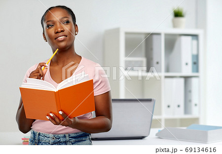 african american woman with notebook at office african american woman with notebook at office 69134616