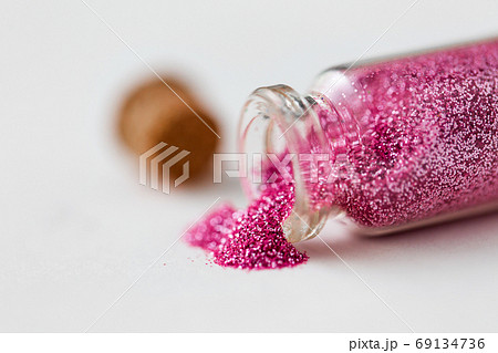 pink glitters poured from small glass bottle pink glitters poured from small glass bottle 69134736