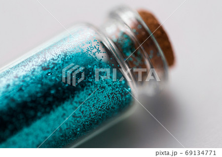 blue glitters in bottle over white background blue glitters in bottle over white background 69134771