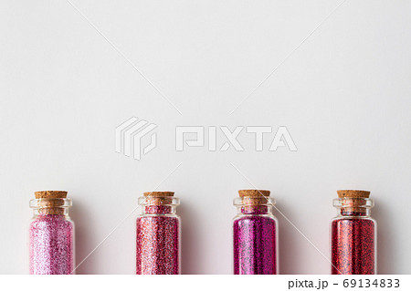 red glitters in bottles over white background red glitters in bottles over white background 69134833