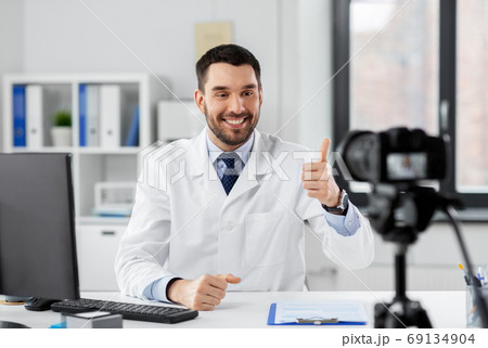 male doctor recording video blog at hospital 69134904