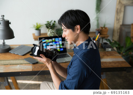 デスクで仕事するカメラマン 69135163