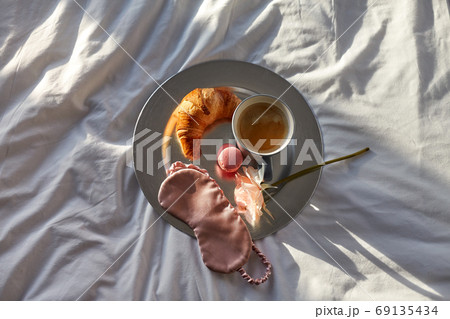 croissant, coffee and eye sleeping mask in bed croissant, coffee and eye sleeping mask in bed 69135434