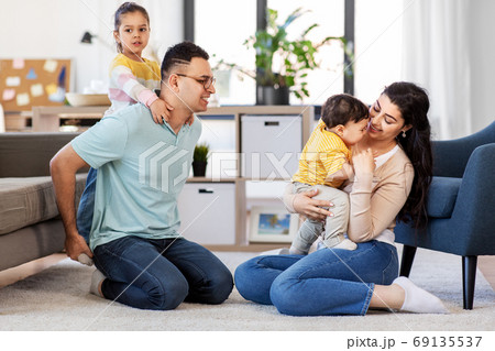 portrait of happy family sitting on sofa at home portrait of happy family sitting on sofa at home 69135537