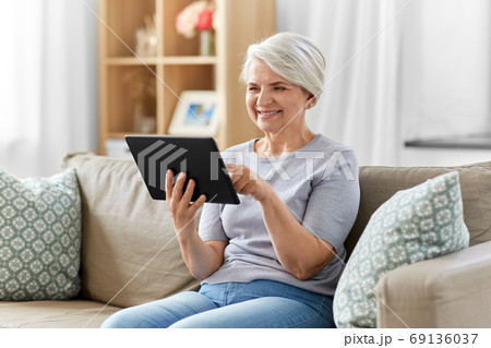 happy senior woman with tablet pc at home happy senior woman with tablet pc at home 69136037