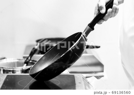Chef cooking in a kitchen, chef at work, Black & White. Chef cooking in a kitchen, chef at work, Black & White. 69136560