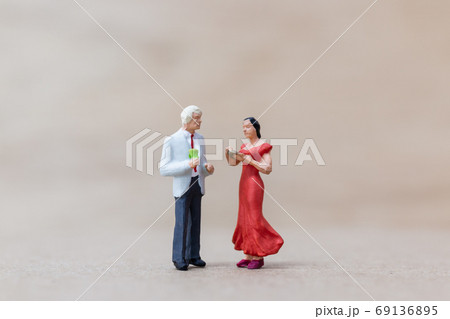 Miniature people , Couple dancing on wooden background Miniature people , Couple dancing on wooden background 69136895