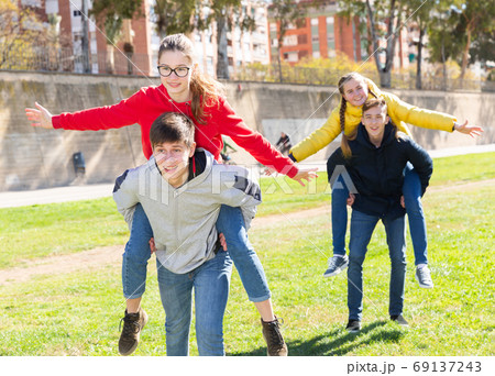 Happy teens compete with each other in park 69137243