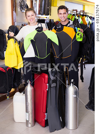 Couple standing with full set equipment for diving Couple standing with full set equipment for diving 69137674