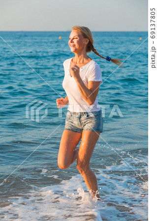 Female in white T-shirt is jogging Female in white T-shirt is jogging 69137805