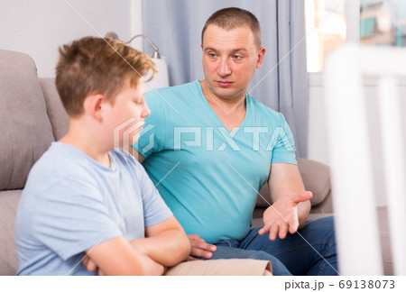 Adult male with his anxious son are resting together and talking about teenage secrets 69138073