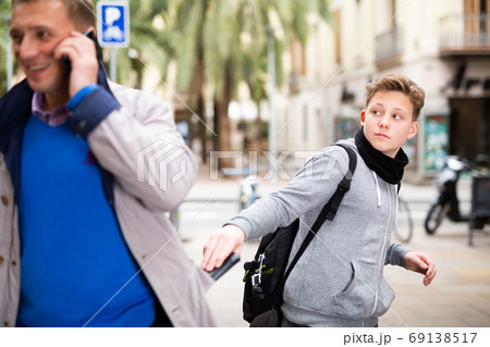 Teenage street thief stealing man wallet Teenage street thief stealing man wallet 69138517