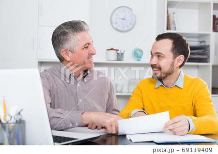 Adult man and agent discuss contract Adult man and agent discuss contract 69139409
