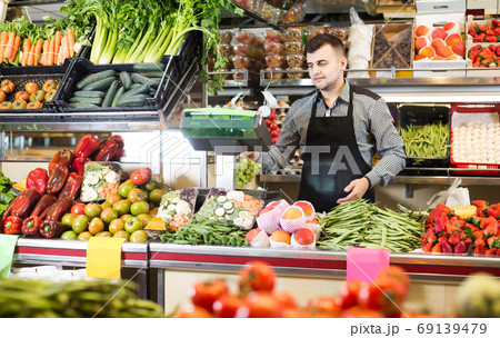 Male shopping assistant weighing grapes in grocery shop Male shopping assistant weighing grapes in grocery shop 69139479