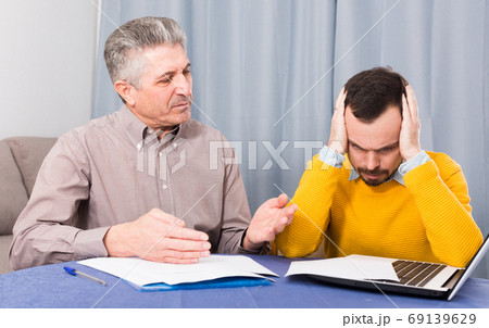 Adult father and son discuss contract Adult father and son discuss contract 69139629
