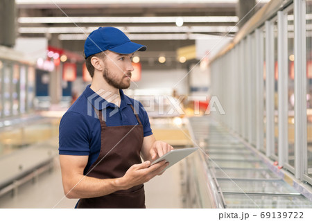 Merchandiser Working In Supermarket Merchandiser Working In Supermarket 69139722