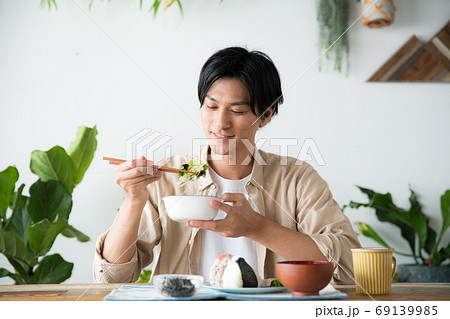 部屋で朝食を食べる男性 69139985