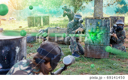 Team of adult people playing paintball on battlefield outdoor, r Team of adult people playing paintball on battlefield outdoor, r 69141450