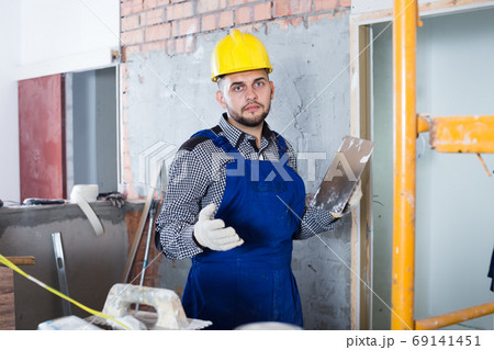 Male ready is plastering the wall Male ready is plastering the wall 69141451