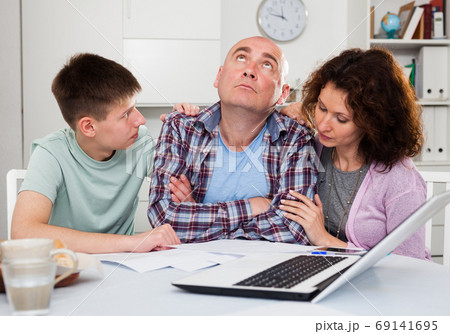 Chagrined family analyzing finances Chagrined family analyzing finances 69141695