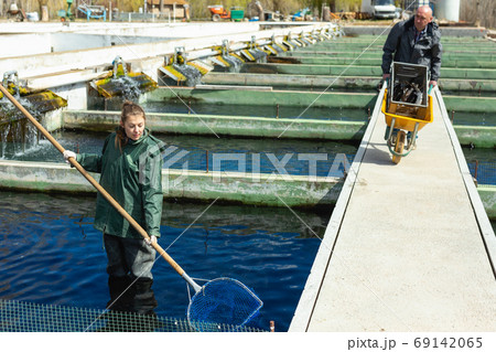 Man and woman working at fish farm 69142065
