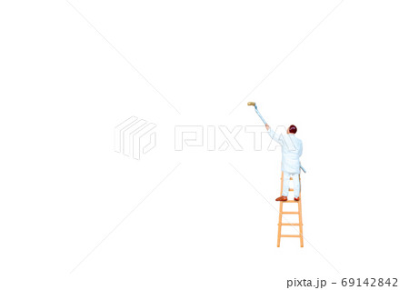 Miniature people with ladder holding brush in front of a white wall background 69142842