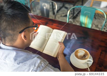 Asian man reading book in free time Asian man reading book in free time 69144335