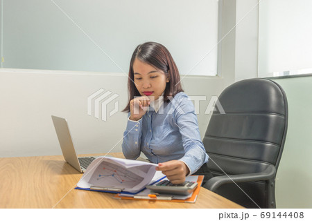 Young businesswoman thinking about new sales report Young businesswoman thinking about new sales report 69144408