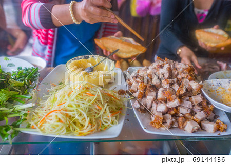 Vietnamese woman making pork sandwich- Banh Mi at hawker vendor Vietnamese woman making pork sandwich- Banh Mi at hawker vendor 69144436