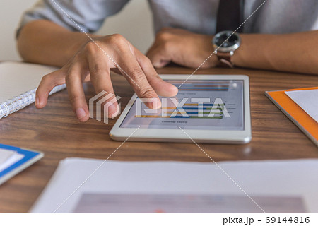 Male hand using tablet to read financial data 69144816