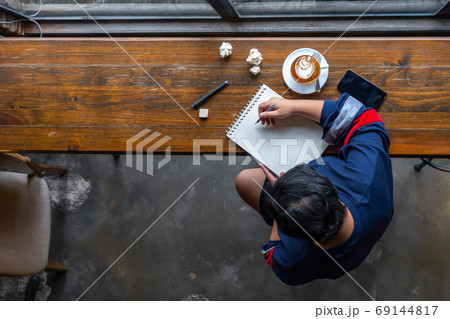 High angle view of Asian student drawing on sketchbook 69144817