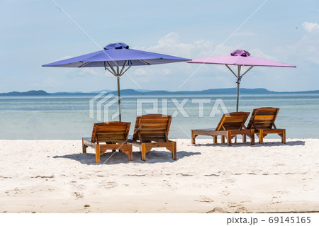 Lounge chairs and umbrella at the white sand beach 69145165