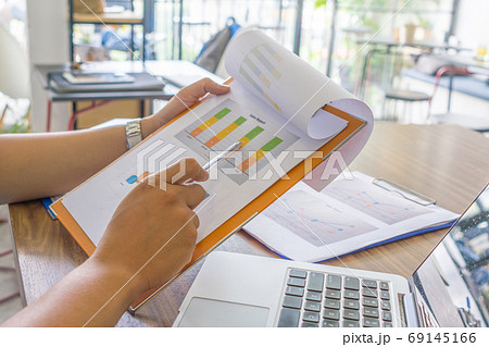 Asian employee checking sales report in office room 69145166