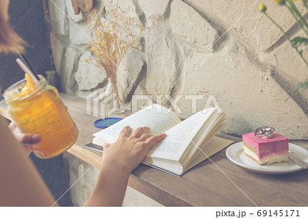 Young woman reading book and drinking tea Young woman reading book and drinking tea 69145171