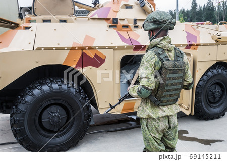 soldier in full armor stands next to military equipment soldier in full armor stands next to military equipment 69145211