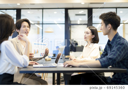 会社のフリースペースで資料を見せながら部下達に方針を説明する上司 会社のフリースペースで資料を見せながら部下達に方針を説明する上司 69145360