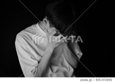 手で顔を覆う男性 69145890