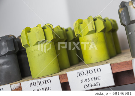 Brand new light green drill bits on shelving in stock. Oil equipment for drilling rig operation on oil platform in oil and gas industry. Written: drill bits 69146981