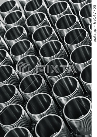 Closeup pattern of shiny circular precision stainless steel industrial machine parts arranged in rows. Steel products to automotive industry. Billet obtained on lathe from steel and cast iron 69147708