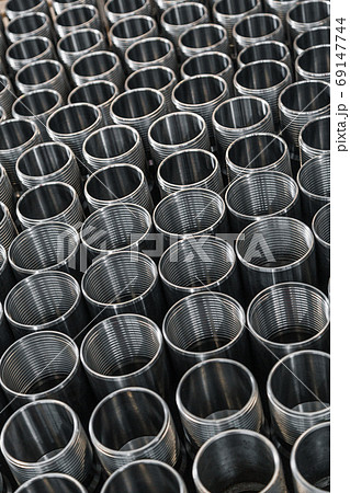 Closeup pattern of shiny circular precision stainless steel industrial machine parts arranged in rows on pallet. Steel products to automotive industry.Billet obtained on lathe from steel and cast iron 69147744