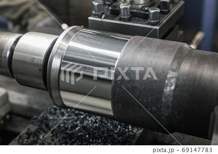 Turning lathe in action. Facing operation of metal blank on turning machine with cutting tool. Old turning lathe machine in turning workshop. Operator machining high precision mold part by cnc lathe 69147783